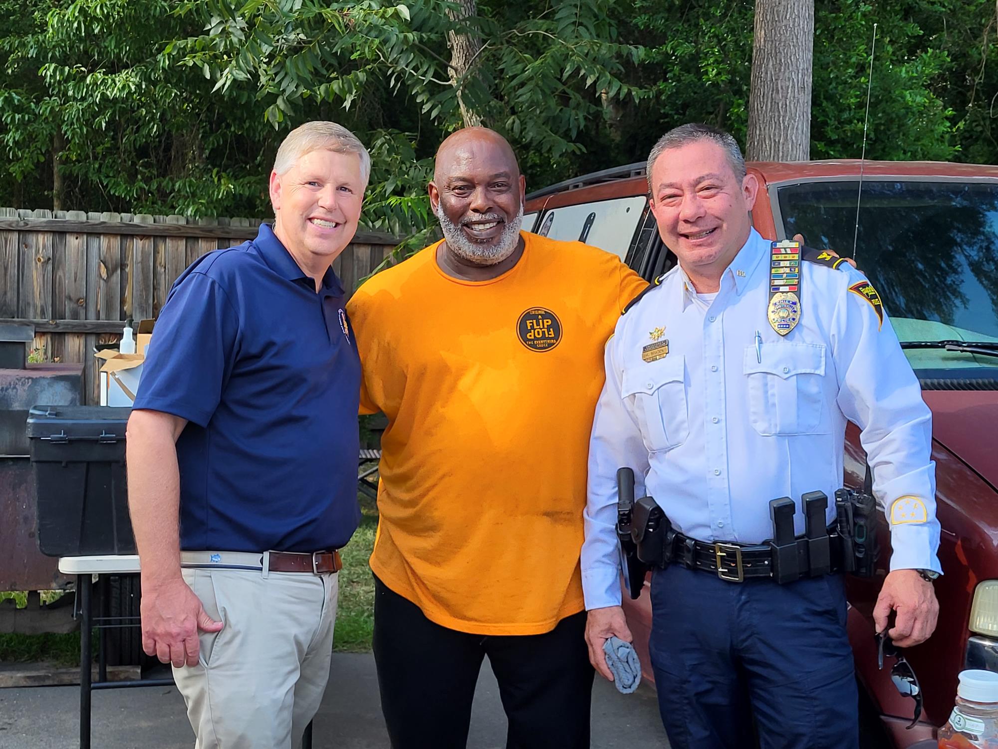 Chief of Police standing with District Attorney and a community member